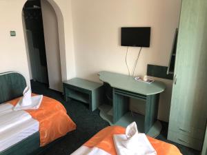 een kamer met 2 bedden en een bureau met een televisie bij Hotel Parc in Alexandria