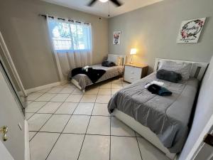 1 dormitorio con 2 camas y suelo de baldosa en Home Wcoffee Station By Pmi Unit Ew, en Fort Lauderdale