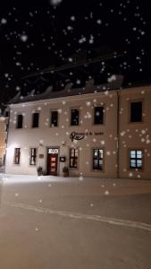 a large white building with a sign on it at night at Pension Rio in Schneeberg