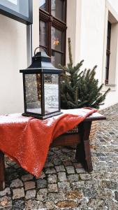 a lantern sitting on a table with a red blanket at Pension Rio in Schneeberg