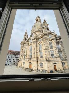 Blick auf ein großes Gebäude durch ein Fenster in der Unterkunft Modernes Apartment mit Blick zur Frauenkirche in Dresden