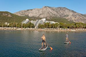 two men on paddle boards in the water at Rixos Sungate - The Land of Legends Access in Beldibi