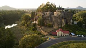 um castelo numa colina com uma casa e uma estrada em Chata pod hradem em Sloup