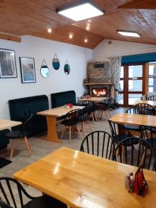 a restaurant with tables and chairs and a fireplace at Widok in Cisna