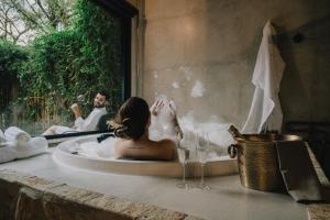 a woman sitting in a bath tub with a man at LaPianta in Monte Verde