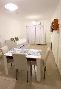 comedor con mesa blanca y sillas en Venezia I - departamento 4 personas en Resistencia