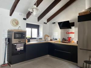 a kitchen with black cabinets and a stove top oven at Lemon House in Vélez-Málaga