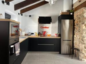 a kitchen with black cabinets and a stainless steel refrigerator at Lemon House in Vélez-Málaga
