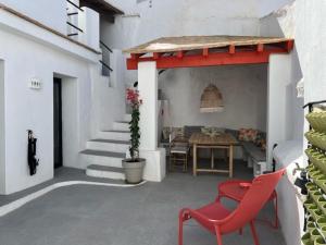 un patio con una silla roja y una mesa en Lemon House en Vélez-Málaga