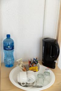 un plato con bolígrafos y una botella de agua en una mesa en Cape Agulhas Guest House, en Agulhas