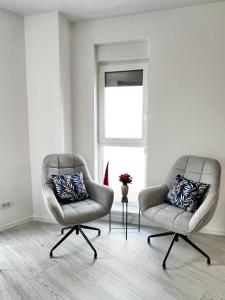 twee stoelen in een kamer met een raam bij Apartment Mara 2 in Timişoara