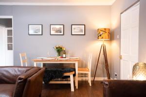 a living room with a table and a couch at Rose Cottage - Seasgair Lodges in Carrbridge