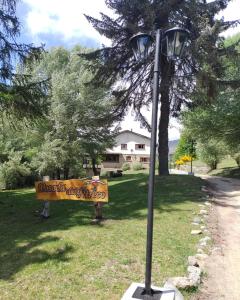 una luz de la calle con un cartel en el césped en Posada del Ñireco en San Carlos de Bariloche