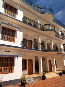 un gran edificio blanco con balcones. en Casa Maria Mystica apartments, Mananthavady, Wayanad en Mānantoddy