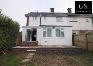 uma casa branca com uma cerca à frente. em 4 Bedroom Modern House, Perfect for Int-Students, Family Relocations, Groups & Contractors by Gurkha Stay Cardiff With Off-Road Parking & WiFi em Cardiff