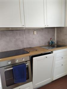 a kitchen with white cabinets and a stove top oven at Hotel Strandbo in Nauvo