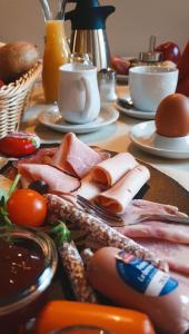 einen Tisch mit Fleisch und Gemüse auf dem Tisch in der Unterkunft Pension Rio in Schneeberg