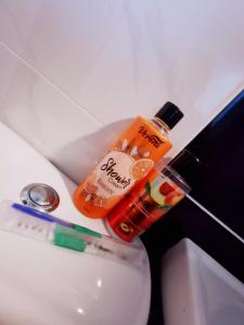 a bottle of sunscreen sitting on top of a toilet at Marvel Suite ABNB in Port Dickson