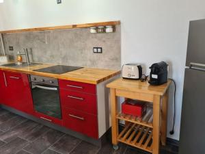 a kitchen with red cabinets and a counter with a stove at Gythio townhouse in Gythio