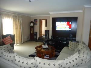 a living room with a couch and a tv at Le Chef BnB in Mthatha