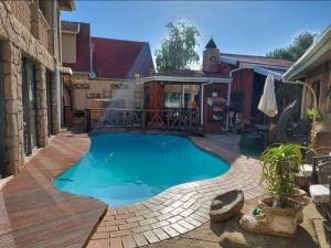 - une piscine dans un jardin avec une terrasse en bois dans l'établissement Le Chef BnB, à Mthatha