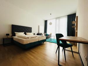 a bedroom with a bed and a table and a desk at Panoramastudio mit Blick zur Frauenkirche in Dresden