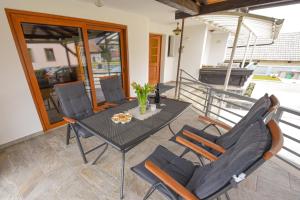 a dining table and chairs on a balcony with an umbrella at Holiday Home Toplica Natura with natural thermal Bath in Cerklje ob Krki