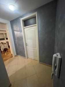 un couloir avec une porte blanche et du carrelage. dans l'établissement Apartman Lana, à Doboj