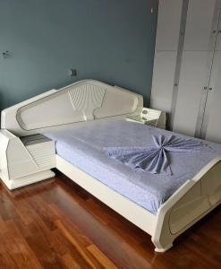 a white bed in a room with a blue mattress at Kifissia center luxury in Athens