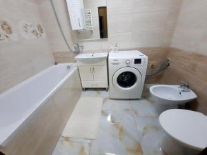 ein Badezimmer mit einem Waschbecken und einer Waschmaschine in der Unterkunft Sun Hall in Lwiw