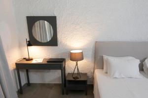 a bedroom with a desk with a bed and a mirror at Apollo Resort in Agia Marina Aegina