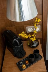 a table with a computer mouse and a vase with flowers at Hôtel Le Colisée in Paris