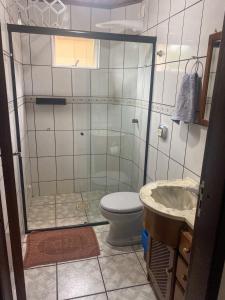 a bathroom with a shower and a toilet and a sink at Pousada das Águas in Piratuba