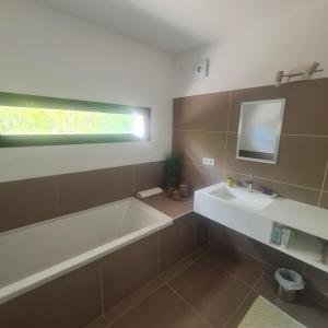 a bathroom with a bath tub and a sink at Villa d'architecte Uzes in Sainte Anastasie - Aubarne