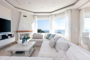 a living room with a white couch and a large window at Villa Panorama in Chania Town