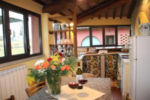 a kitchen with a table with a vase of flowers at Mulino Di Rimaggio in Cavriglia