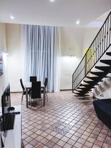 une salle à manger avec une table et un escalier dans l'établissement Terno su Napoli Apartments, à Naples
