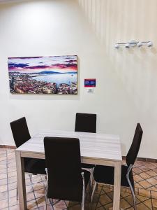 une table à manger avec des chaises et un tableau mural dans l'établissement Terno su Napoli Apartments, à Naples