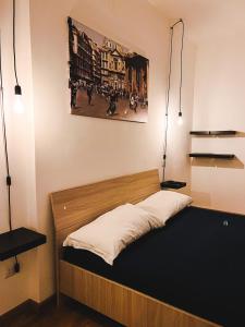 - un lit dans une chambre avec une photo sur le mur dans l'établissement Terno su Napoli Apartments, à Naples