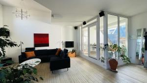 uma sala de estar com um sofá preto e uma grande janela em ApartmentInCopenhagen Apartment 158 em Copenhague