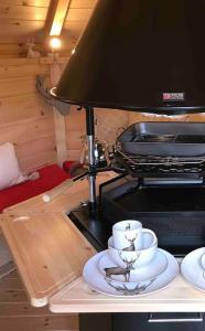 a table with two cups and a lamp on it at Romantic Treehouse with Hot Tub & BBQ Lodge in Praze an Beeble