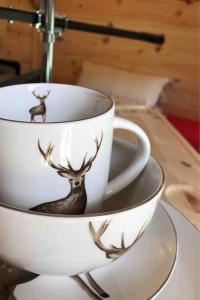 two coffee cups with deer on them on a table at Romantic Treehouse with Hot Tub & BBQ Lodge in Praze an Beeble
