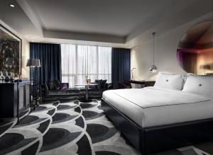 a hotel room with a bed and a living room at Bisha Hotel Toronto in Toronto