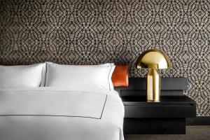 a bedroom with a bed and a patterned wall at Bisha Hotel Toronto in Toronto