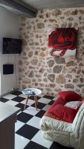 een woonkamer met een bank en een stenen muur bij locationseians var studio mimosa 2 etage in Seillans