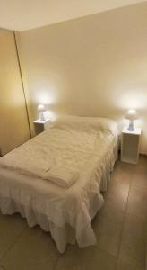 1 dormitorio con 1 cama blanca grande y 2 mesas en Venezia I - departamento 4 personas en Resistencia