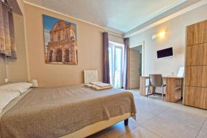 1 dormitorio con 1 cama grande y escritorio con ordenador en B&B Viale San Pietro, en Sassari