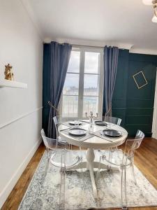 een eetkamer met een tafel en stoelen en een raam bij Grand appart Chic centre ville 4 pers wifi in Pontoise