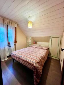 - une chambre avec un lit et une couverture rayée dans l'établissement STUPENDO 3 CAMERE, PISCINA, BOX, VICINISSIMO PISTE, à Prato Nevoso