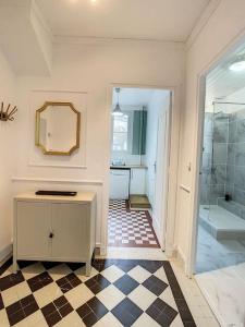 a bathroom with a shower and a checkered floor at Grand appart Chic centre ville 4 pers wifi in Pontoise